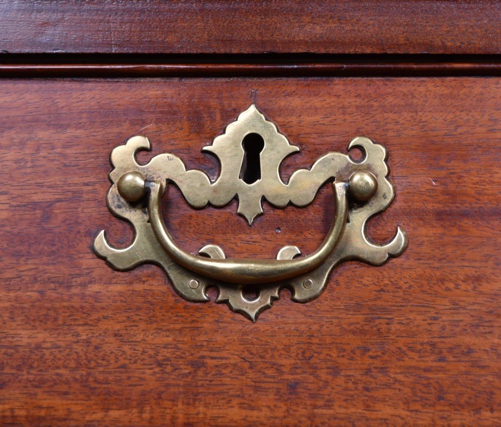 A tall Georgian mahogany chest on chest featuring two stacked tiers of drawers with brass swan-neck handles resting on bracket feet. View III