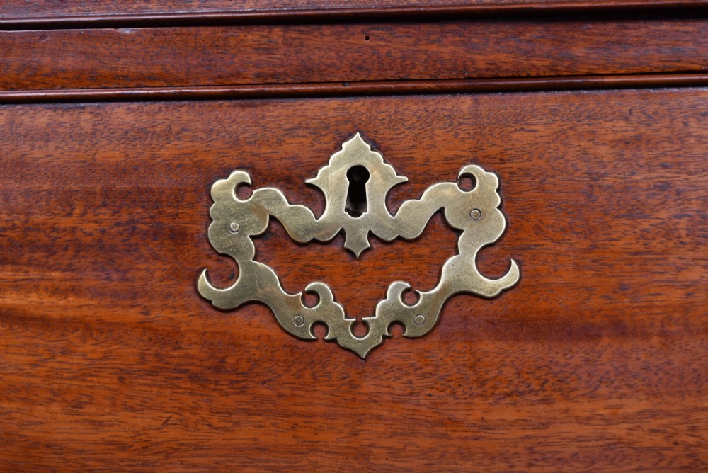 A tall Georgian mahogany chest on chest featuring two stacked tiers of drawers with brass swan-neck handles resting on bracket feet. View V