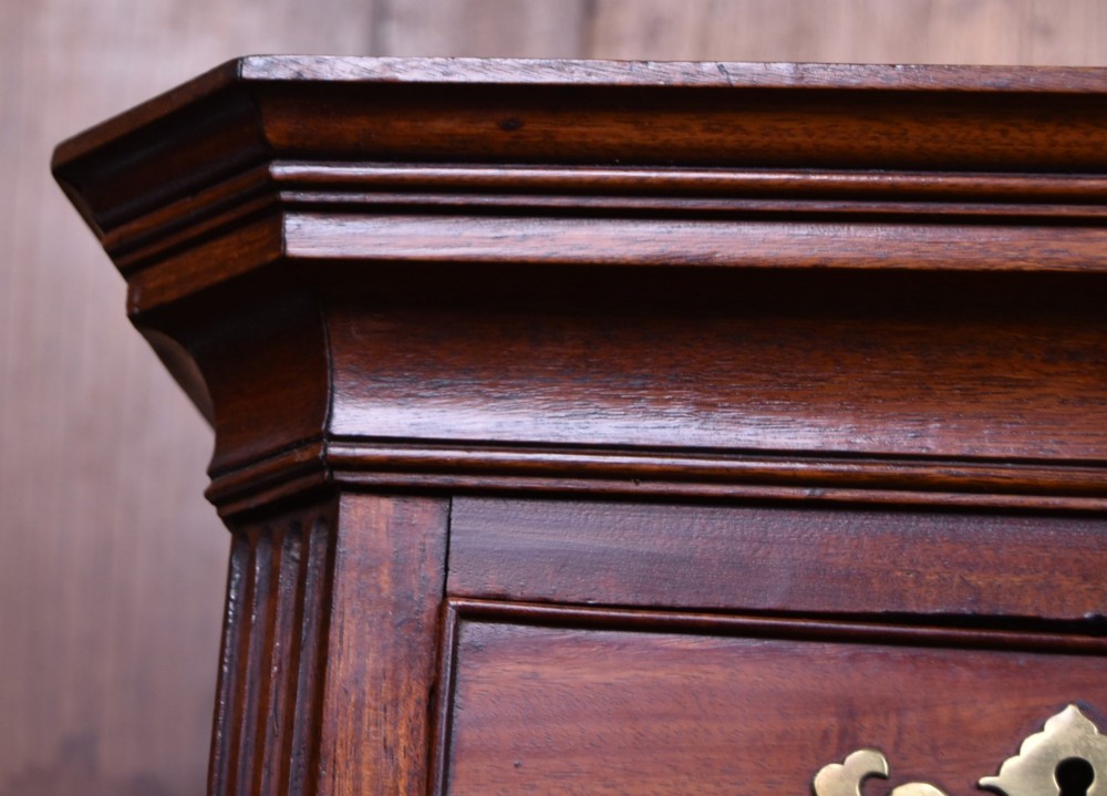 A tall Georgian mahogany chest on chest featuring two stacked tiers of drawers with brass swan-neck handles resting on bracket feet. View VI