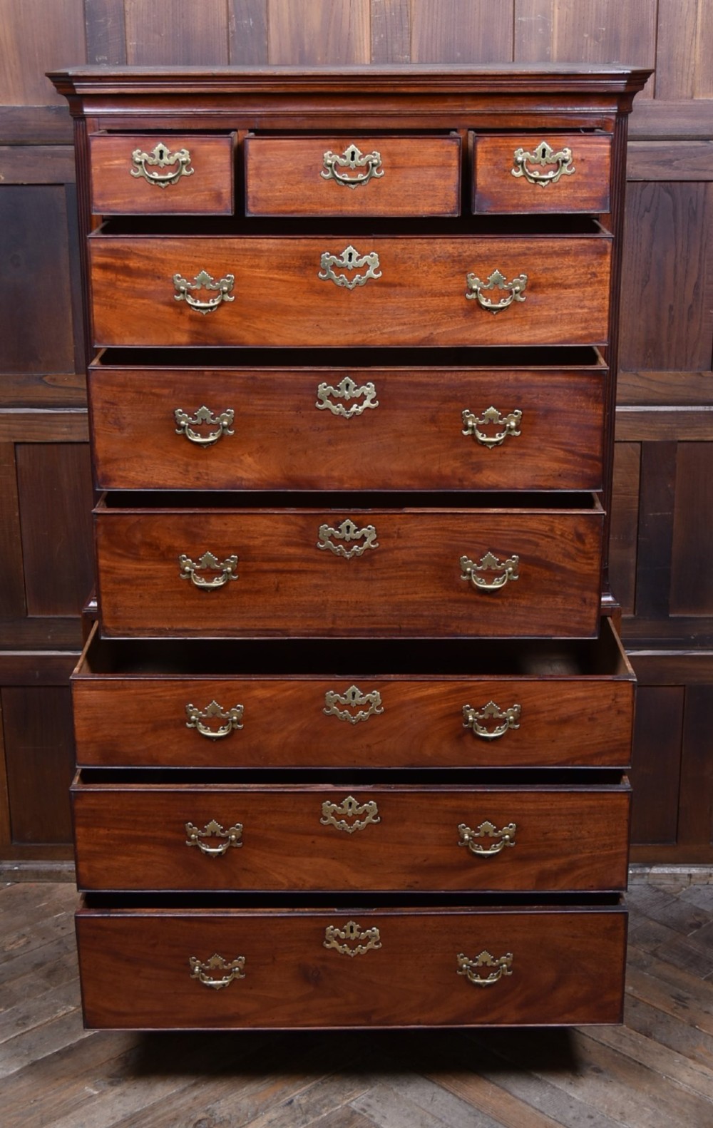 A tall Georgian mahogany chest on chest featuring two stacked tiers of drawers with brass swan-neck handles resting on bracket feet. View VIII