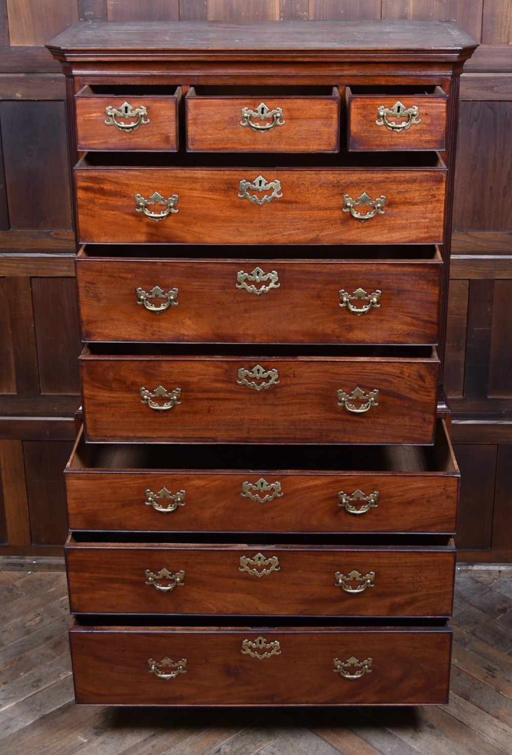 A tall Georgian mahogany chest on chest featuring two stacked tiers of drawers with brass swan-neck handles resting on bracket feet. View IX
