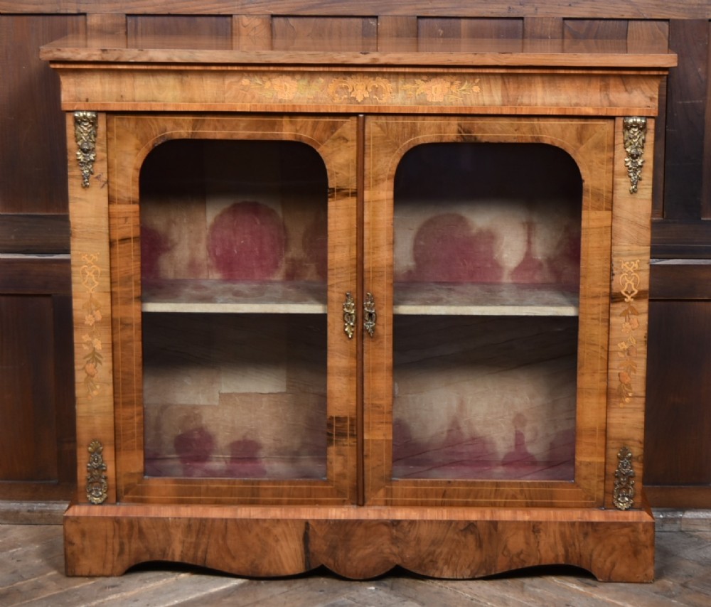 A Victorian walnut pier cabinet featuring double glazed arched doors, floral marquetry inlay, and decorative ormolu mounts. View II