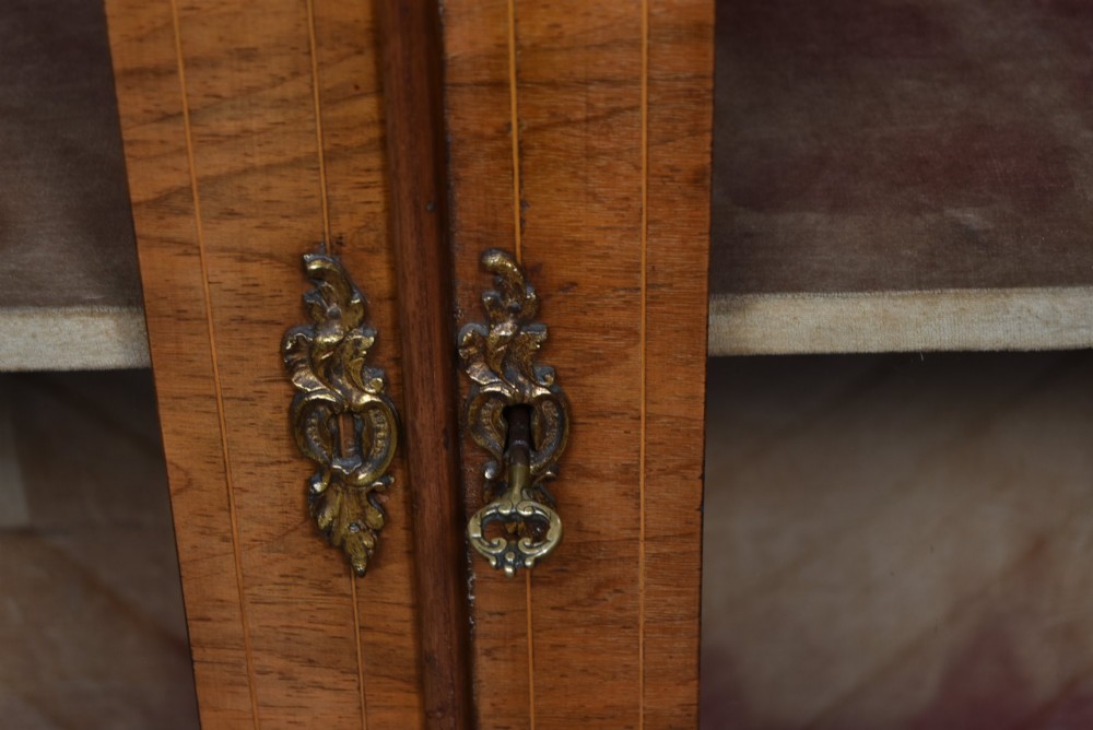 A Victorian walnut pier cabinet featuring double glazed arched doors, floral marquetry inlay, and decorative ormolu mounts. View VI