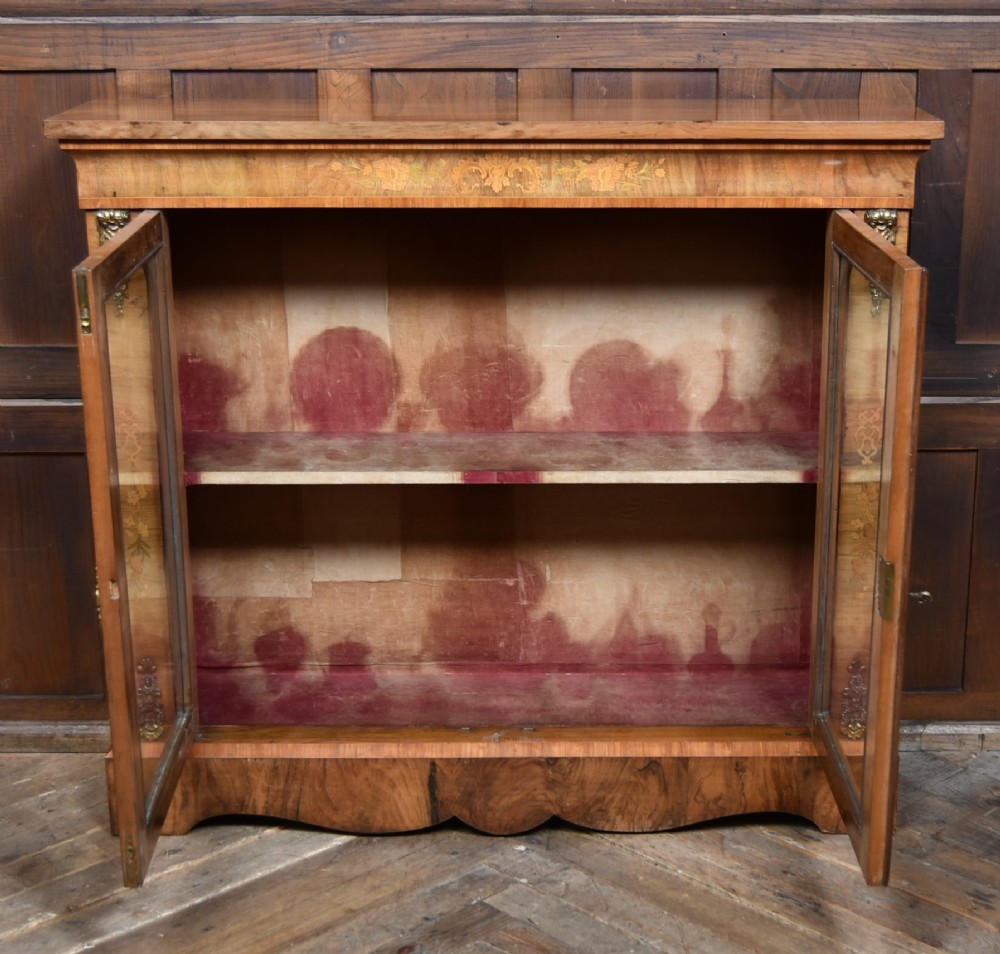 A Victorian walnut pier cabinet featuring double glazed arched doors, floral marquetry inlay, and decorative ormolu mounts. View VII