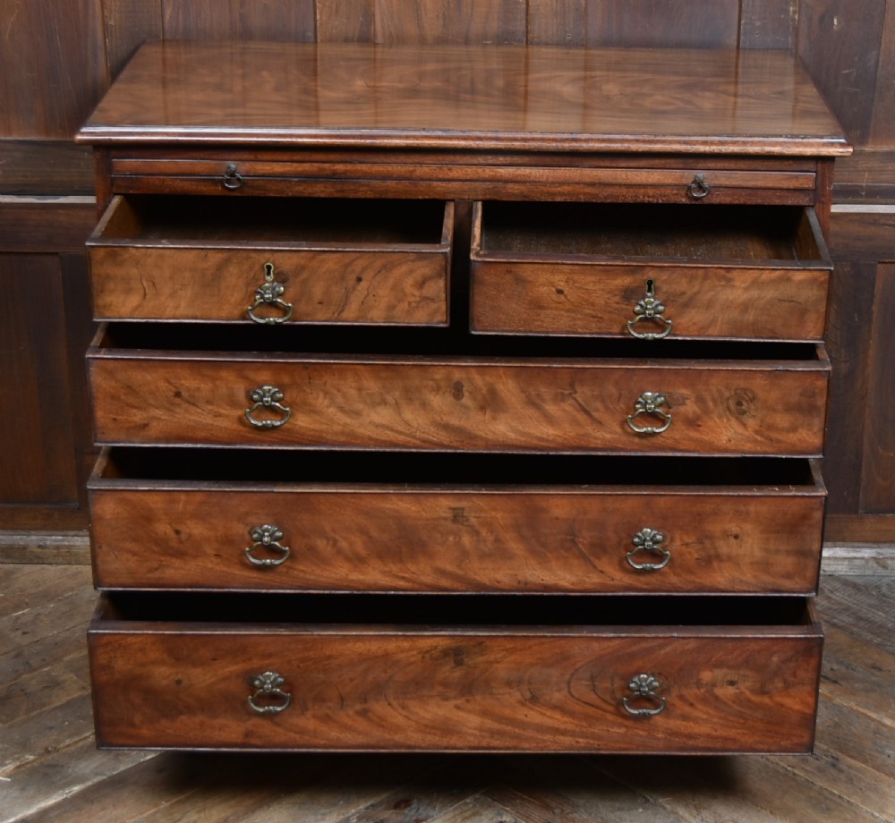 An 18th-century Georgian mahogany chest of drawers with a pull-out brushing slide, two short over three long graduated drawers, brass bail handles, and bracket feet. View IX