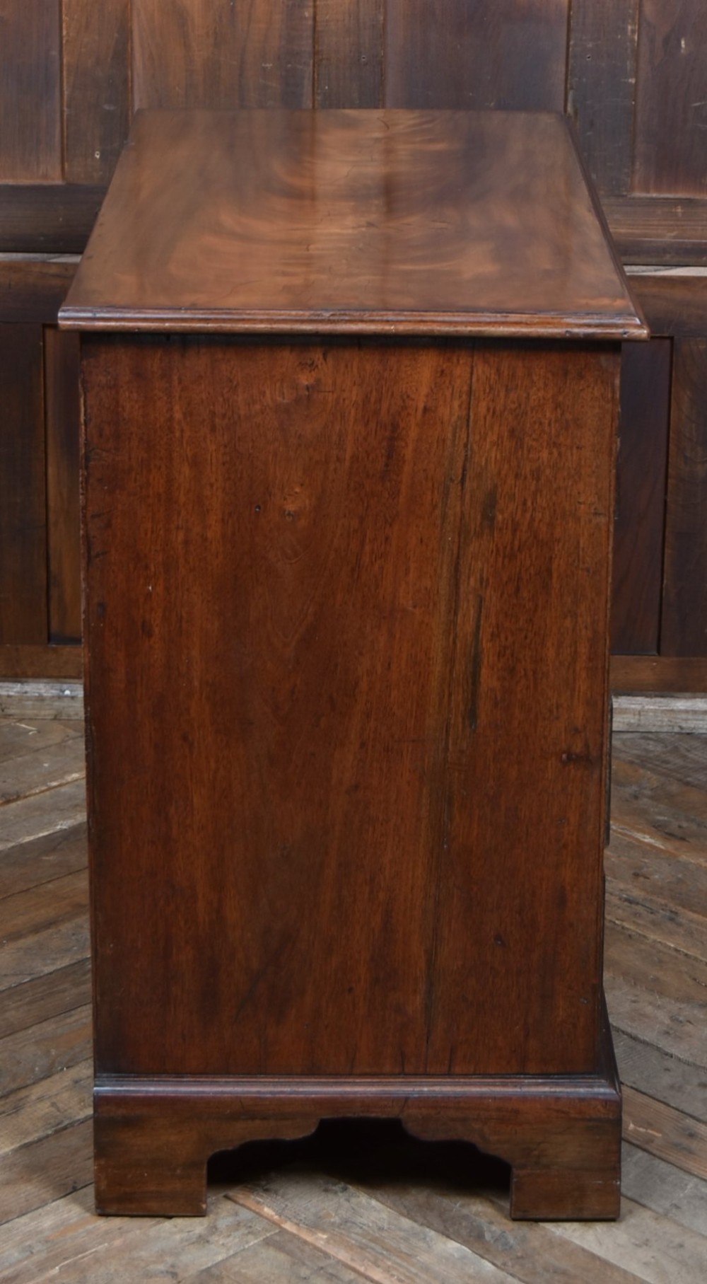 An 18th-century Georgian mahogany chest of drawers with a pull-out brushing slide, two short over three long graduated drawers, brass bail handles, and bracket feet. View XI