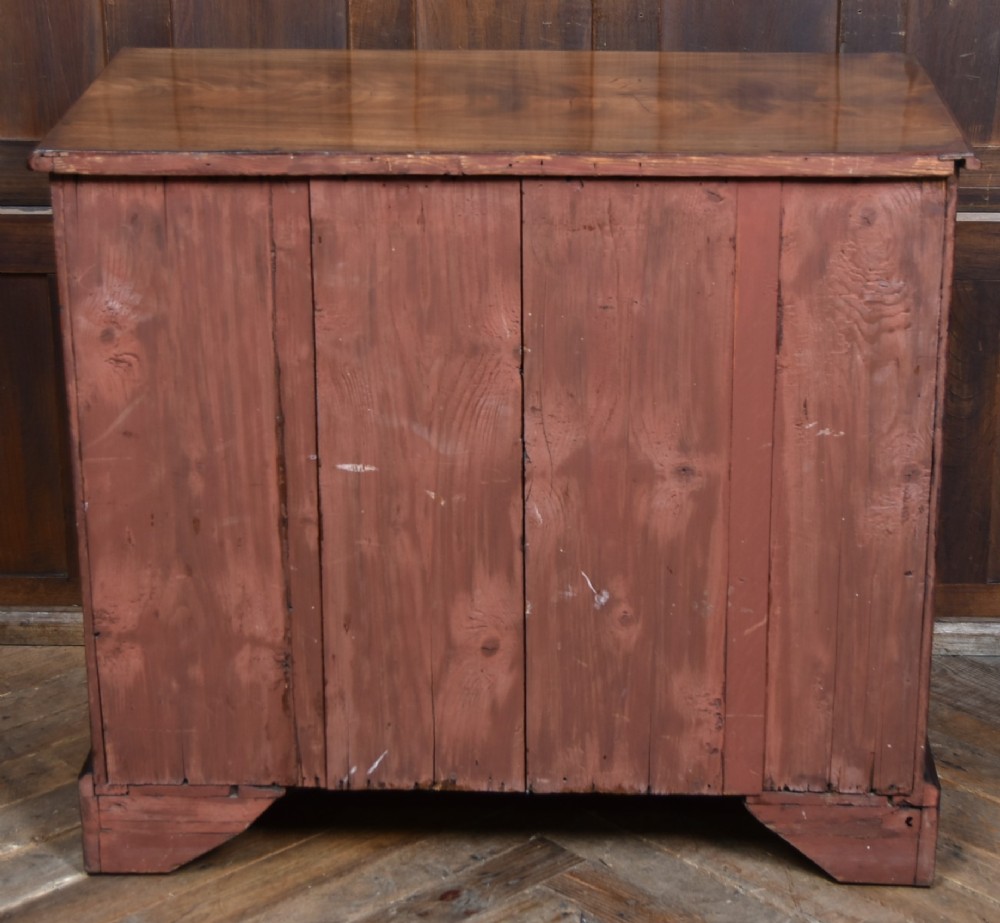 An 18th-century Georgian mahogany chest of drawers with a pull-out brushing slide, two short over three long graduated drawers, brass bail handles, and bracket feet. View XII