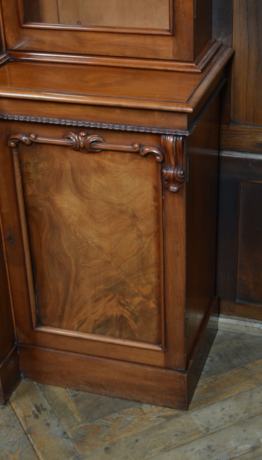A large Victorian mahogany breakfront bookcase featuring four glazed upper doors and four panelled lower cupboard doors with carved details. View XIII