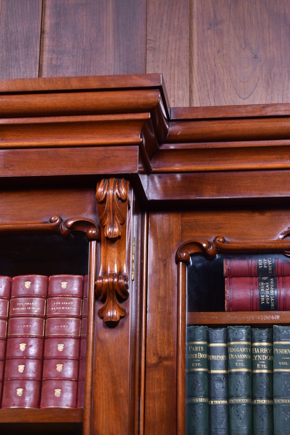 A large Victorian mahogany breakfront bookcase featuring four glazed upper doors and four panelled lower cupboard doors with carved details. View XIV