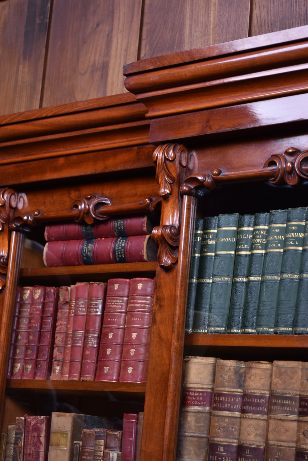 A large Victorian mahogany breakfront bookcase featuring four glazed upper doors and four panelled lower cupboard doors with carved details. View XV