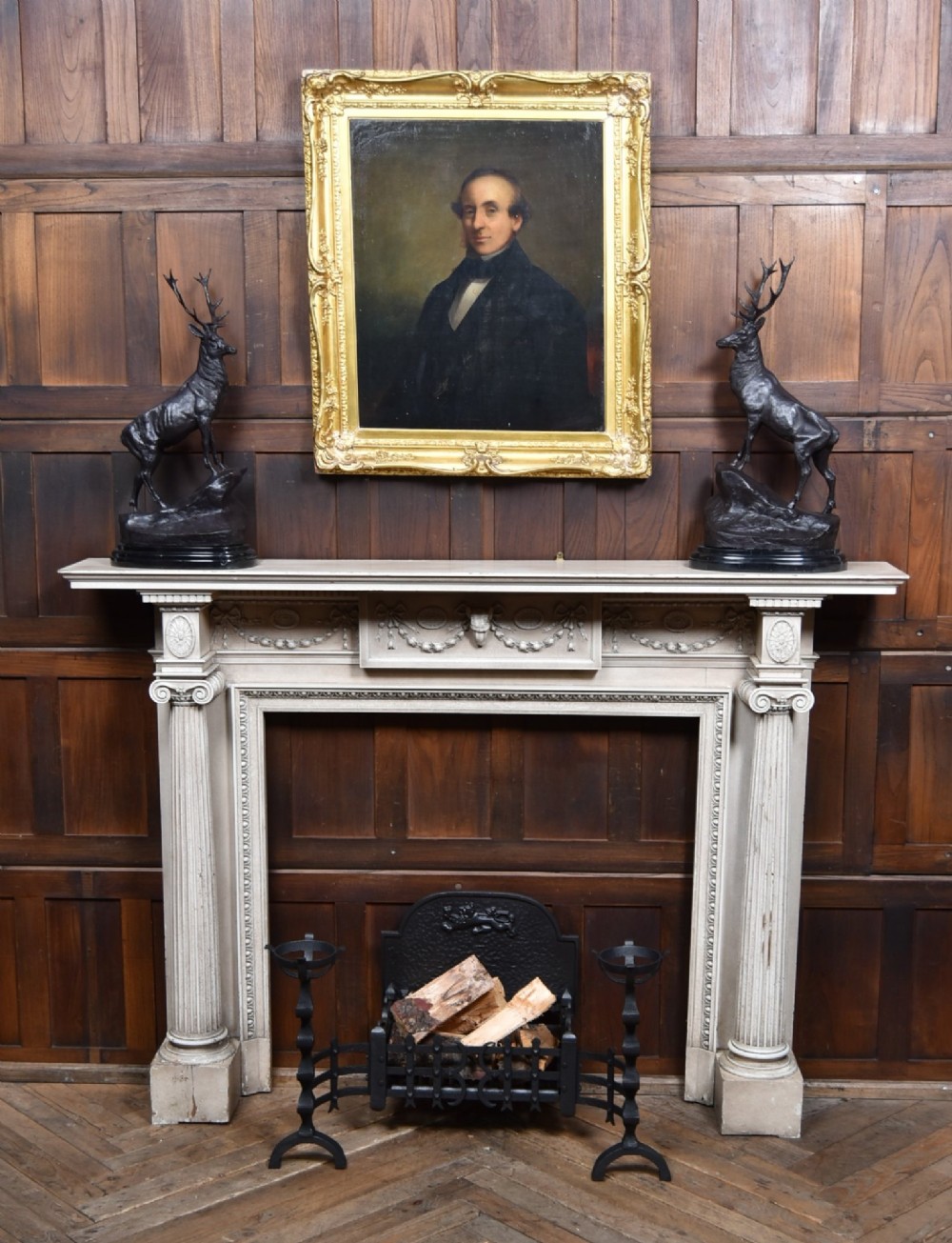 An off-white painted Neoclassical fireplace surround featuring fluted columns and swags, paired with a black cast iron fire grate. View II