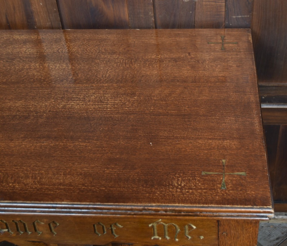 A Victorian oak church communion table with carved Gothic arch panels and a carved inscription reading Do this in Remembrance of me along the top frieze. View VII