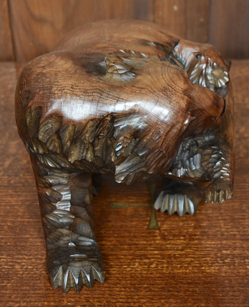A hand-carved warm brown wooden sculpture depicting a mother bear with a cub clinging to her side. View IV