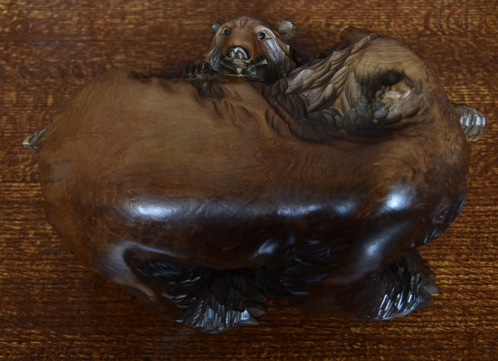 A hand-carved warm brown wooden sculpture depicting a mother bear with a cub clinging to her side. View VI