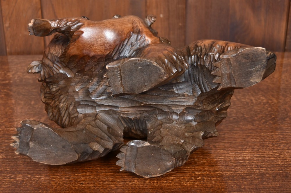 A hand-carved warm brown wooden sculpture depicting a mother bear with a cub clinging to her side. View IX