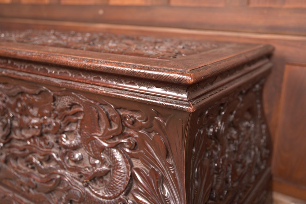A dark brown rectangular carved hardwood storage chest decorated with high-relief dragon and cloud motifs on all visible faces. View II