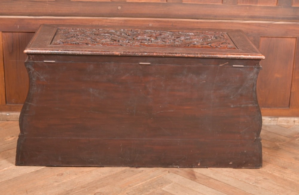 A dark brown rectangular carved hardwood storage chest decorated with high-relief dragon and cloud motifs on all visible faces. View IX