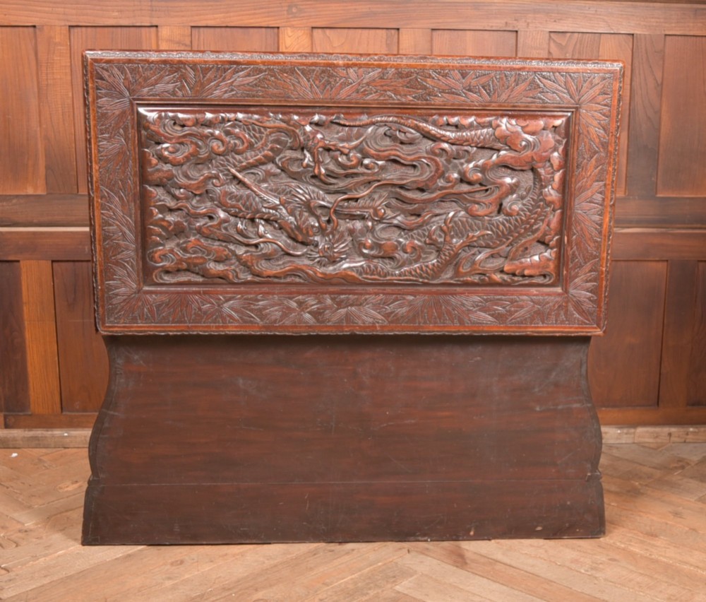 A dark brown rectangular carved hardwood storage chest decorated with high-relief dragon and cloud motifs on all visible faces. View X