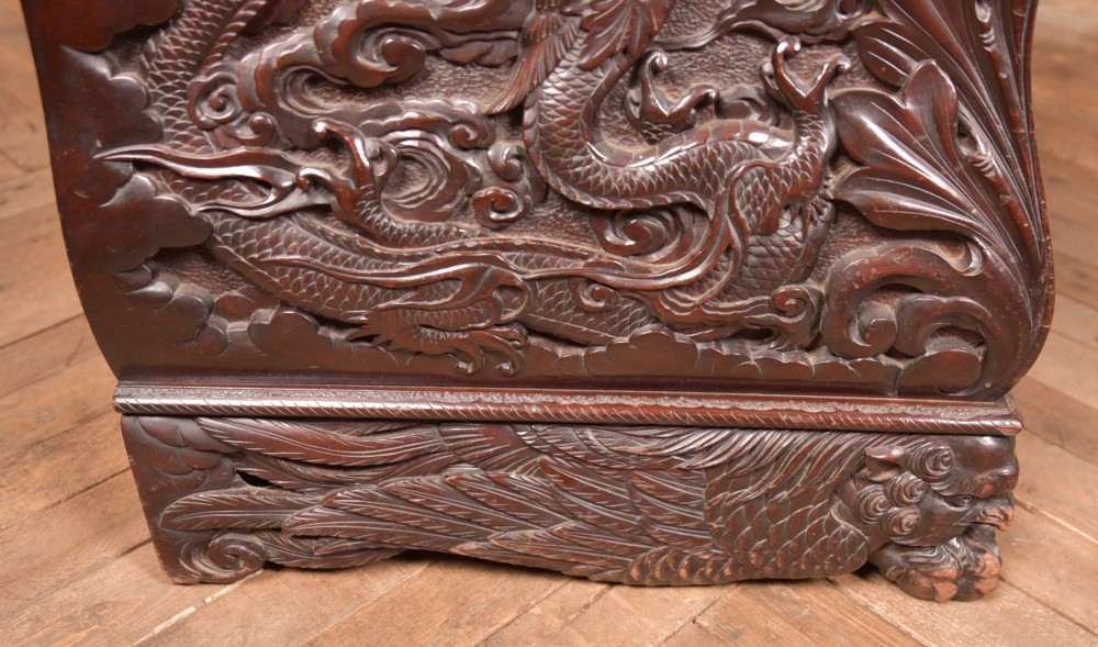 A dark brown rectangular carved hardwood storage chest decorated with high-relief dragon and cloud motifs on all visible faces. View XV