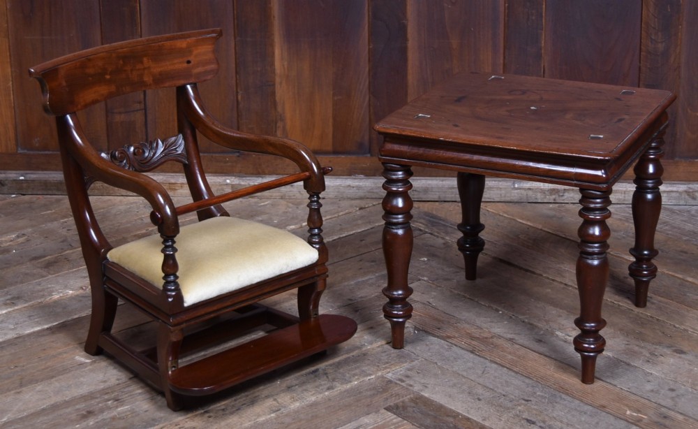 A Victorian metamorphic mahogany childs high chair with turned legs, curved armrests, a carved backrest crest, and cream fabric upholstery. View VIII