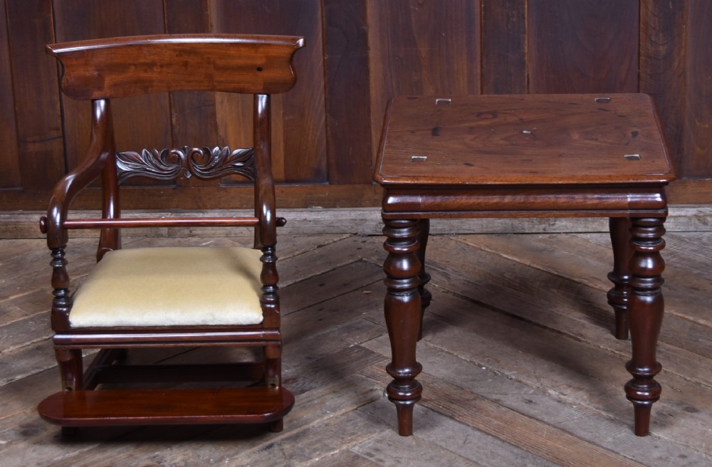 A Victorian metamorphic mahogany childs high chair with turned legs, curved armrests, a carved backrest crest, and cream fabric upholstery. View IX