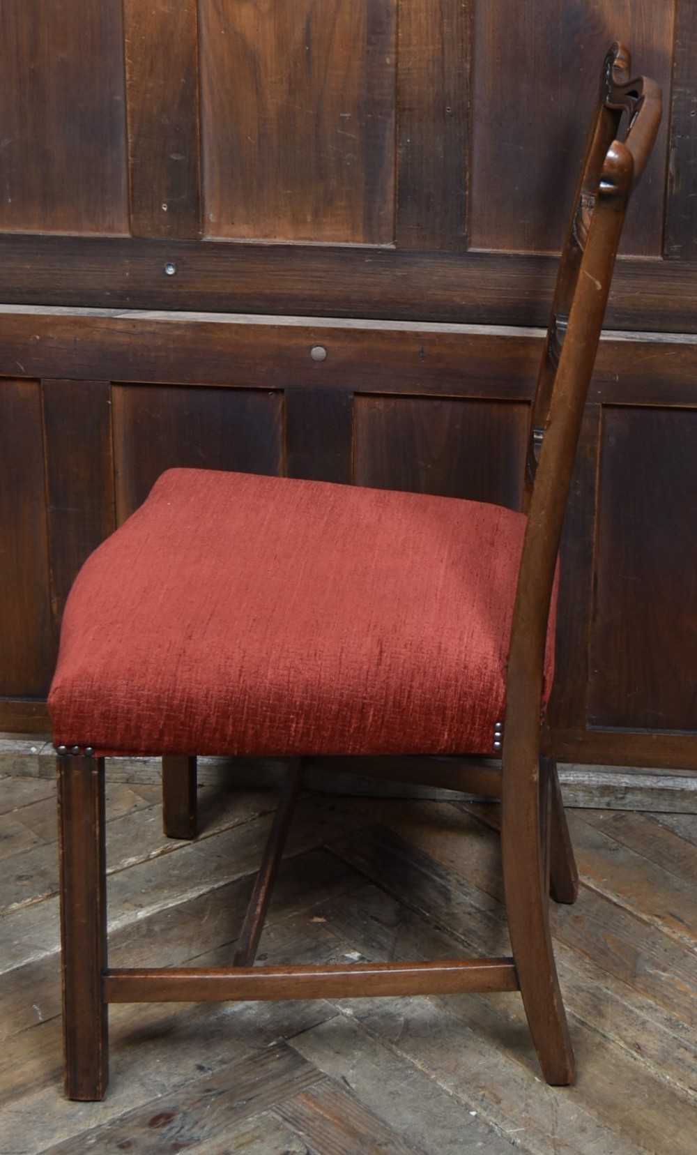 A set of Chippendale Revival mahogany dining chairs featuring carved ladder-back splats and red upholstered seats. View VII