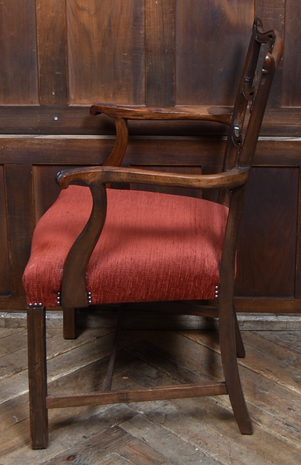 A set of Chippendale Revival mahogany dining chairs featuring carved ladder-back splats and red upholstered seats. View X