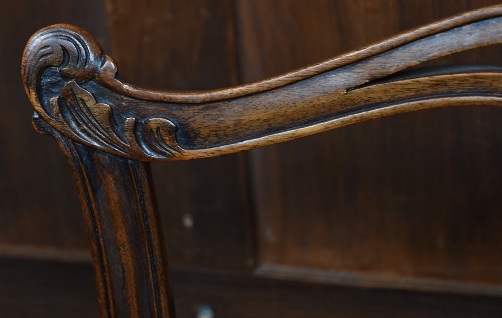 A set of Chippendale Revival mahogany dining chairs featuring carved ladder-back splats and red upholstered seats. View XI