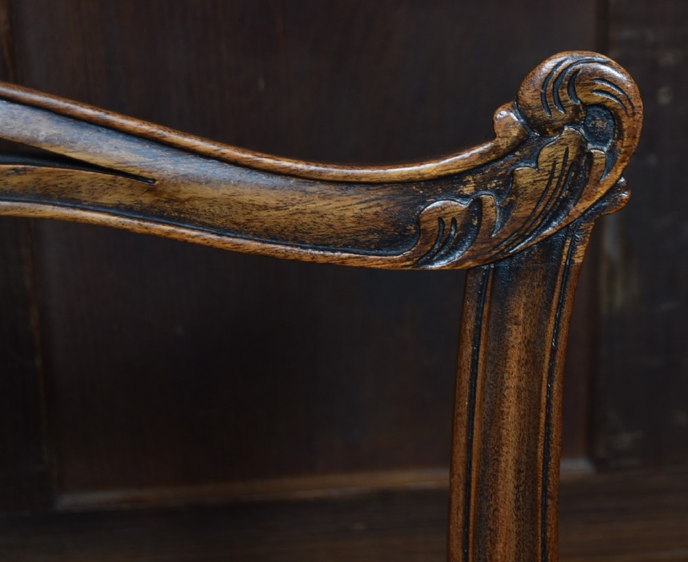 A set of Chippendale Revival mahogany dining chairs featuring carved ladder-back splats and red upholstered seats. View XII