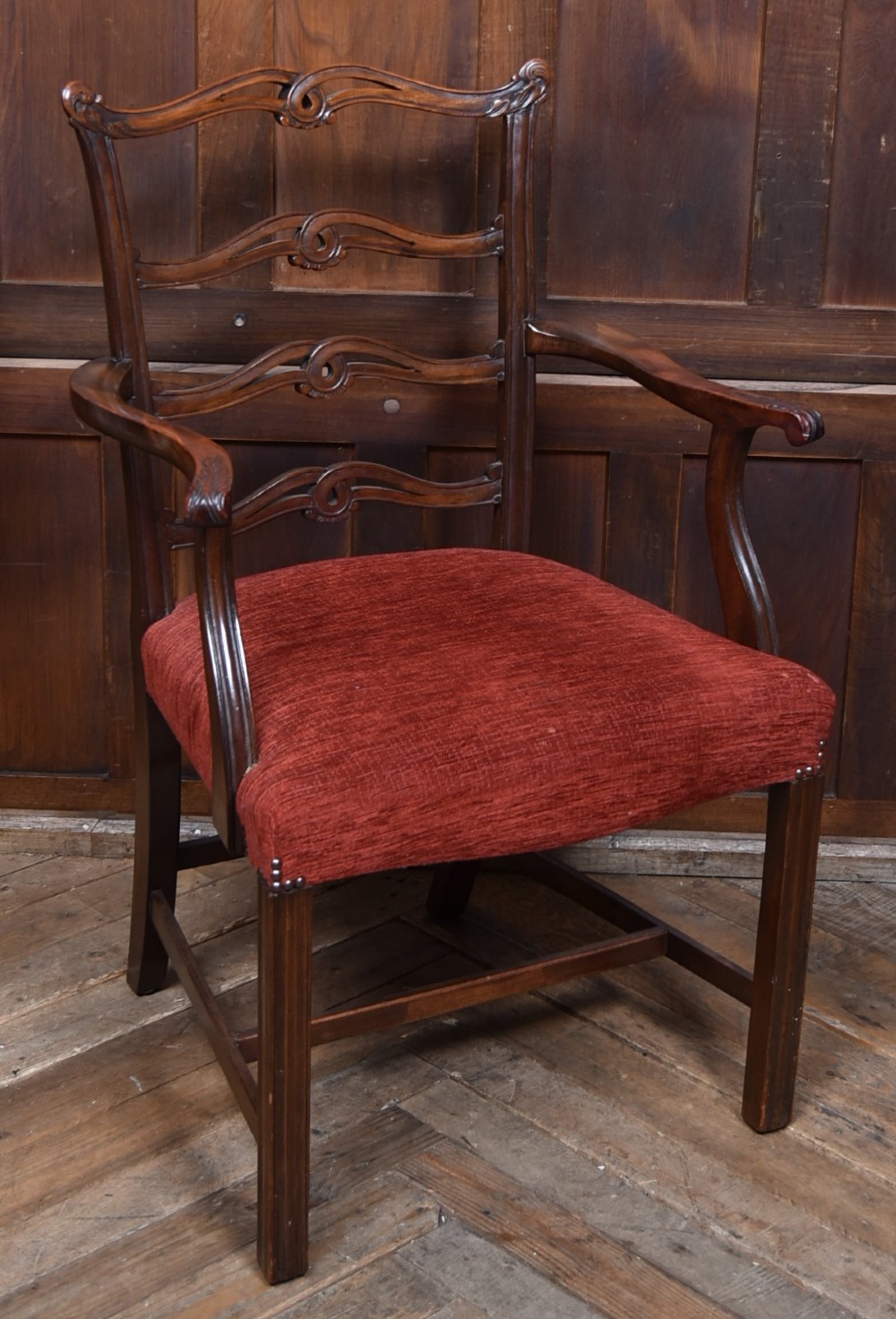 A set of Chippendale Revival mahogany dining chairs featuring carved ladder-back splats and red upholstered seats. View XIV