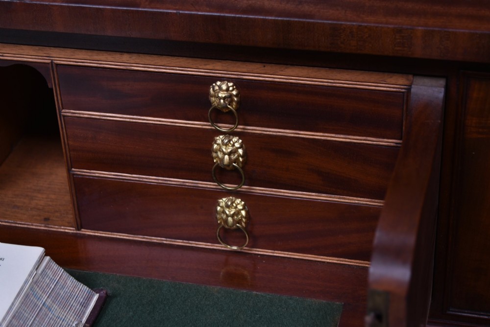 A large 19th-century flame mahogany secretaire bookcase featuring four glazed upper doors with arched astragal glazing, above a drop-down desk compartment fitted with drawers and a green writing surface. View III