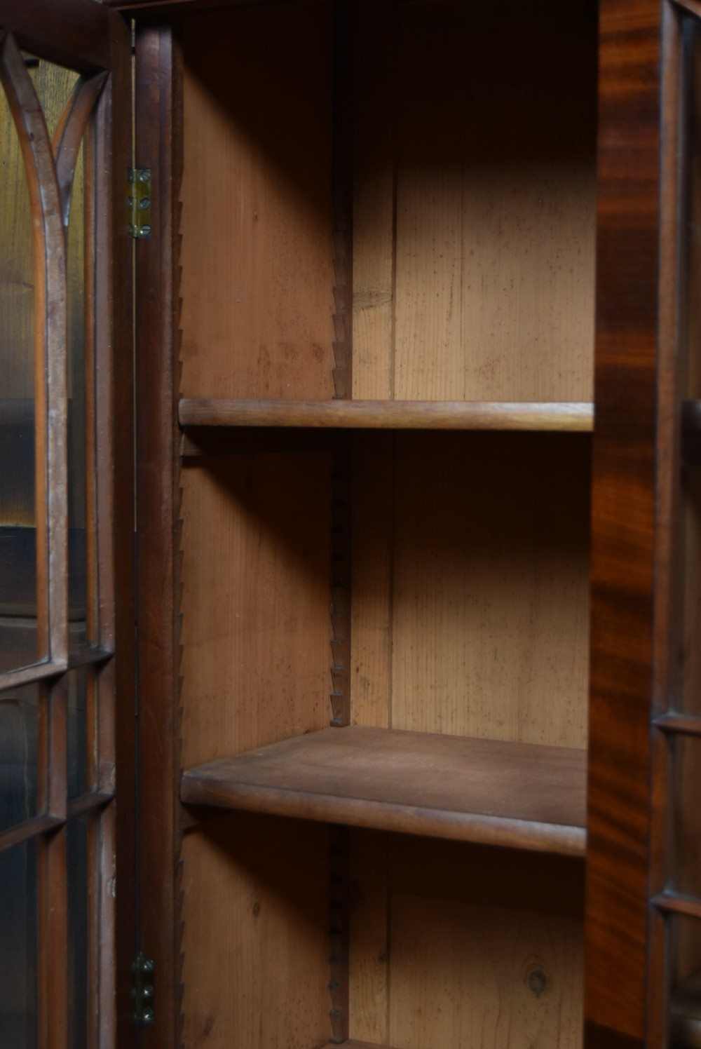A large 19th-century flame mahogany secretaire bookcase featuring four glazed upper doors with arched astragal glazing, above a drop-down desk compartment fitted with drawers and a green writing surface. View IX