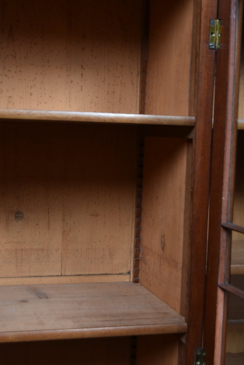 A large 19th-century flame mahogany secretaire bookcase featuring four glazed upper doors with arched astragal glazing, above a drop-down desk compartment fitted with drawers and a green writing surface. View X