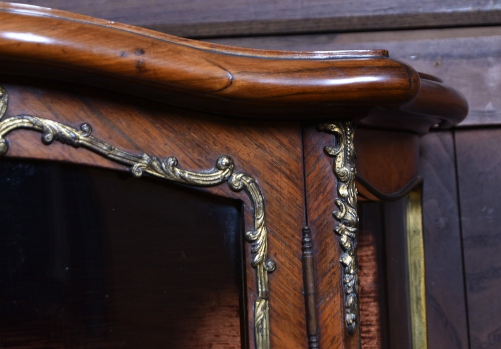 A French walnut vitrine cabinet featuring curved glass upper panels, gilt-bronze ormolu mounts, cabriole legs, and a hand-painted lower door panel depicting a figurative scene. View VI
