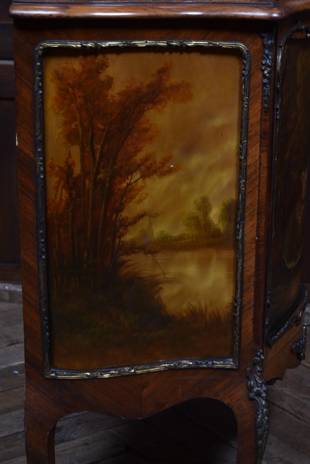 A French walnut vitrine cabinet featuring curved glass upper panels, gilt-bronze ormolu mounts, cabriole legs, and a hand-painted lower door panel depicting a figurative scene. View XII