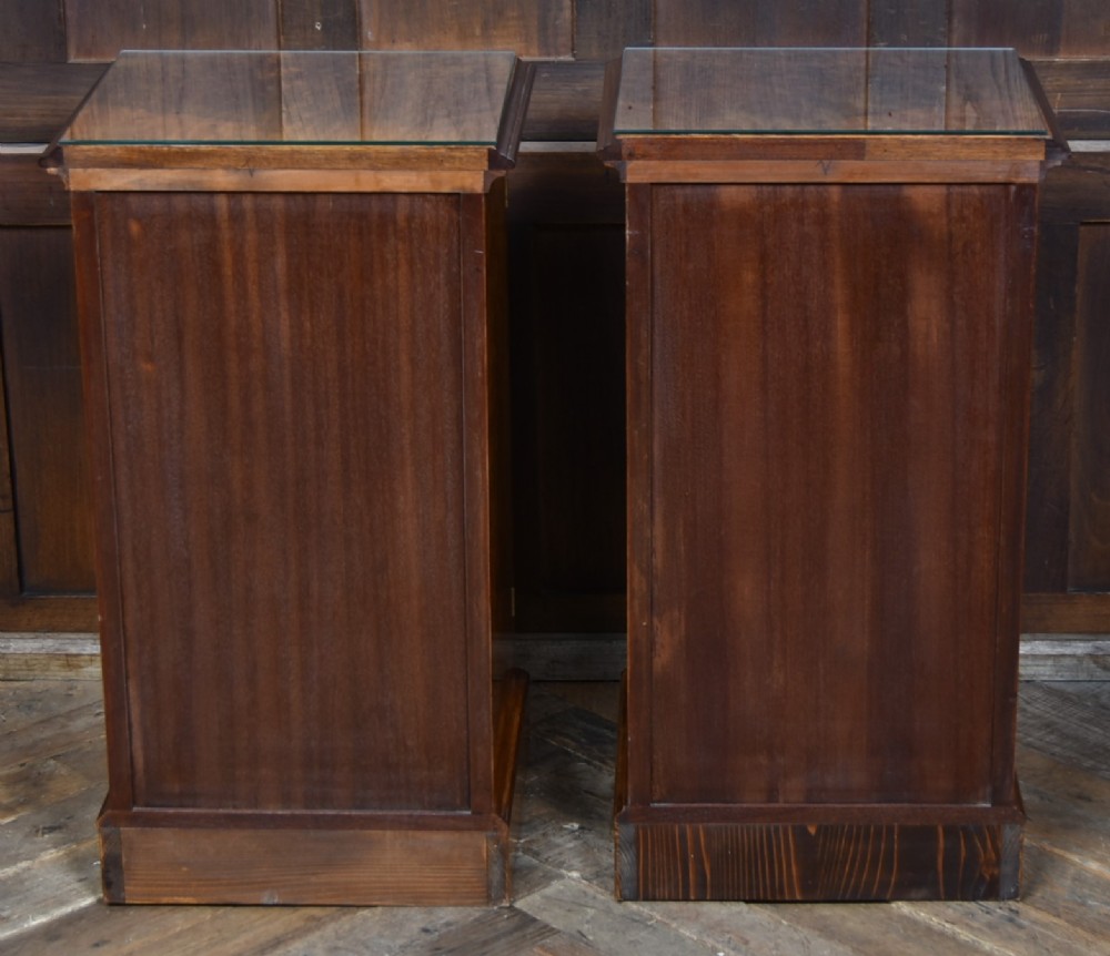 A matching pair of Edwardian burr walnut bedside pot cupboards featuring central marquetry inlays, single doors, glass tops, and plinth bases. View VIII