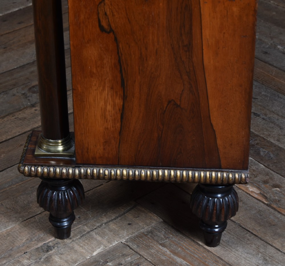 A Victorian dark rosewood chiffonier cabinet featuring a decorative brass inlay border, brass mask accents, two pleated silk fabric door panels, turned feet, and a raised upper tier shelf. View XII