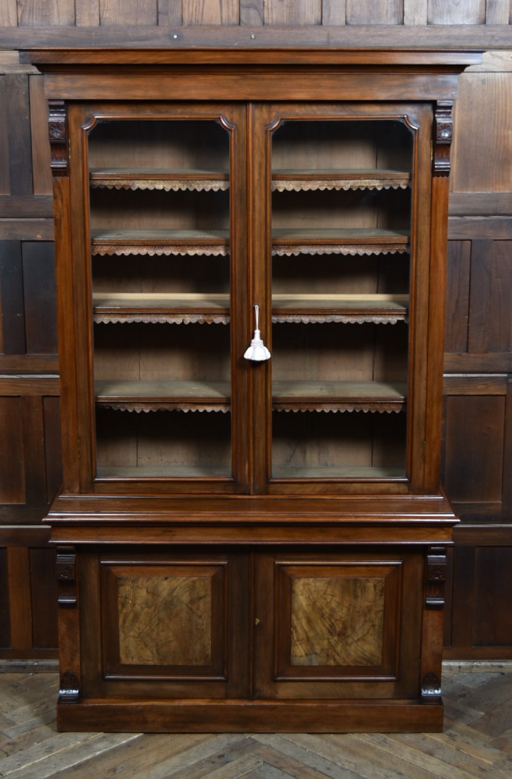 An Edwardian walnut glazed bookcase featuring a two-door upper section with glass panels, adjustable interior shelving, and a lower cabinet with burr walnut door panels. View III