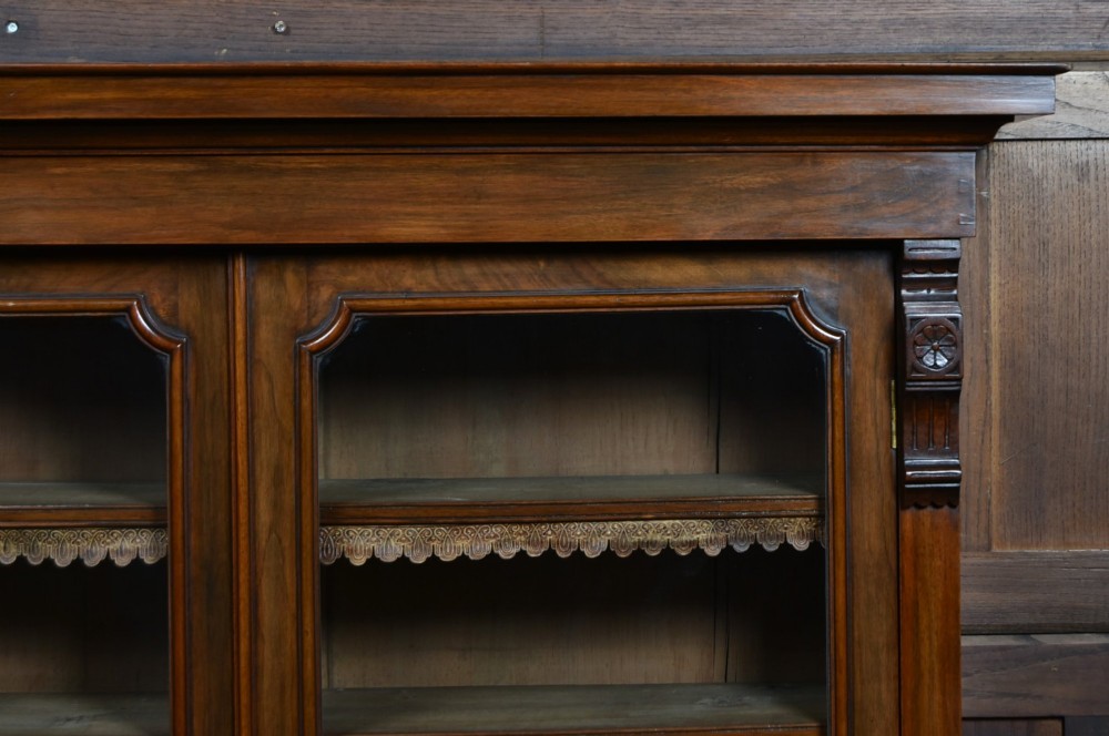 An Edwardian walnut glazed bookcase featuring a two-door upper section with glass panels, adjustable interior shelving, and a lower cabinet with burr walnut door panels. View V