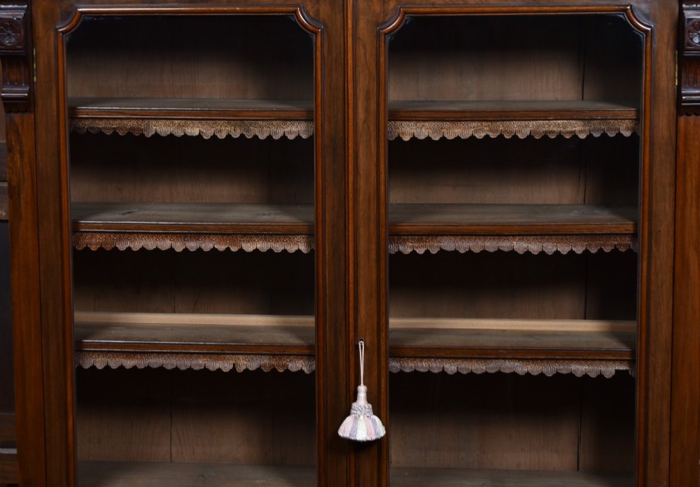 An Edwardian walnut glazed bookcase featuring a two-door upper section with glass panels, adjustable interior shelving, and a lower cabinet with burr walnut door panels. View VI