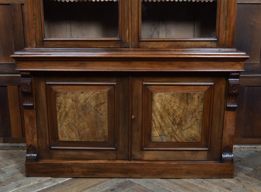 An Edwardian walnut glazed bookcase featuring a two-door upper section with glass panels, adjustable interior shelving, and a lower cabinet with burr walnut door panels. View IX