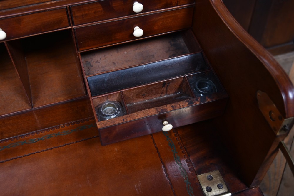 An early nineteenth-century mahogany secretaire bookcase featuring a swan-neck pediment, astragal glazed upper doors, and a lower chest of drawers with brass lion-head handles. View III