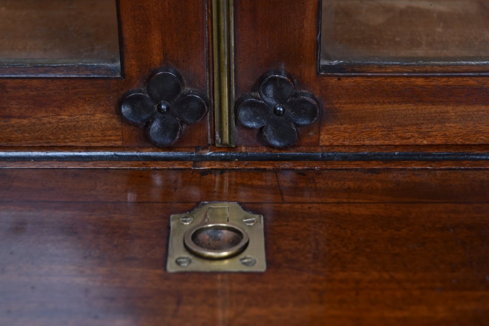 An early nineteenth-century mahogany secretaire bookcase featuring a swan-neck pediment, astragal glazed upper doors, and a lower chest of drawers with brass lion-head handles. View IX