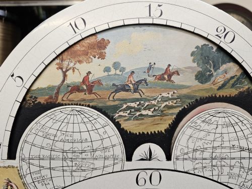 fig 4. A Regency mahogany longcase clock featuring a swan-neck pediment, a painted dial with a moonphase complication, and a Gothic arch door with flame mahogany veneers.