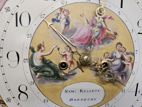 fig 5. A Regency mahogany longcase clock featuring a swan-neck pediment, a painted dial with a moonphase complication, and a Gothic arch door with flame mahogany veneers.