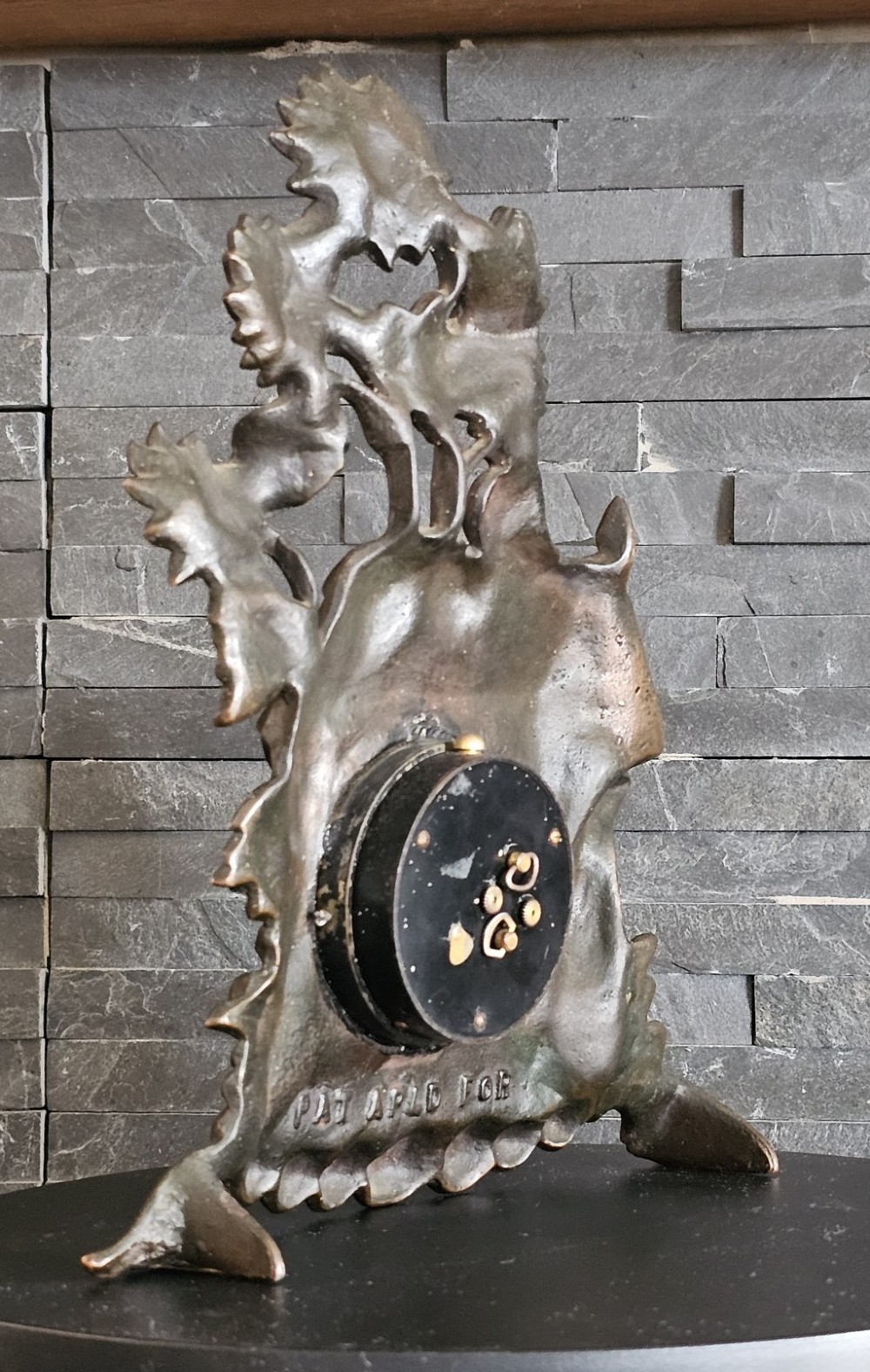 A bronzed Art Deco table clock shaped like a dog kennel with sunflowers on top and a dog figure on the left side of the circular dial. View IV