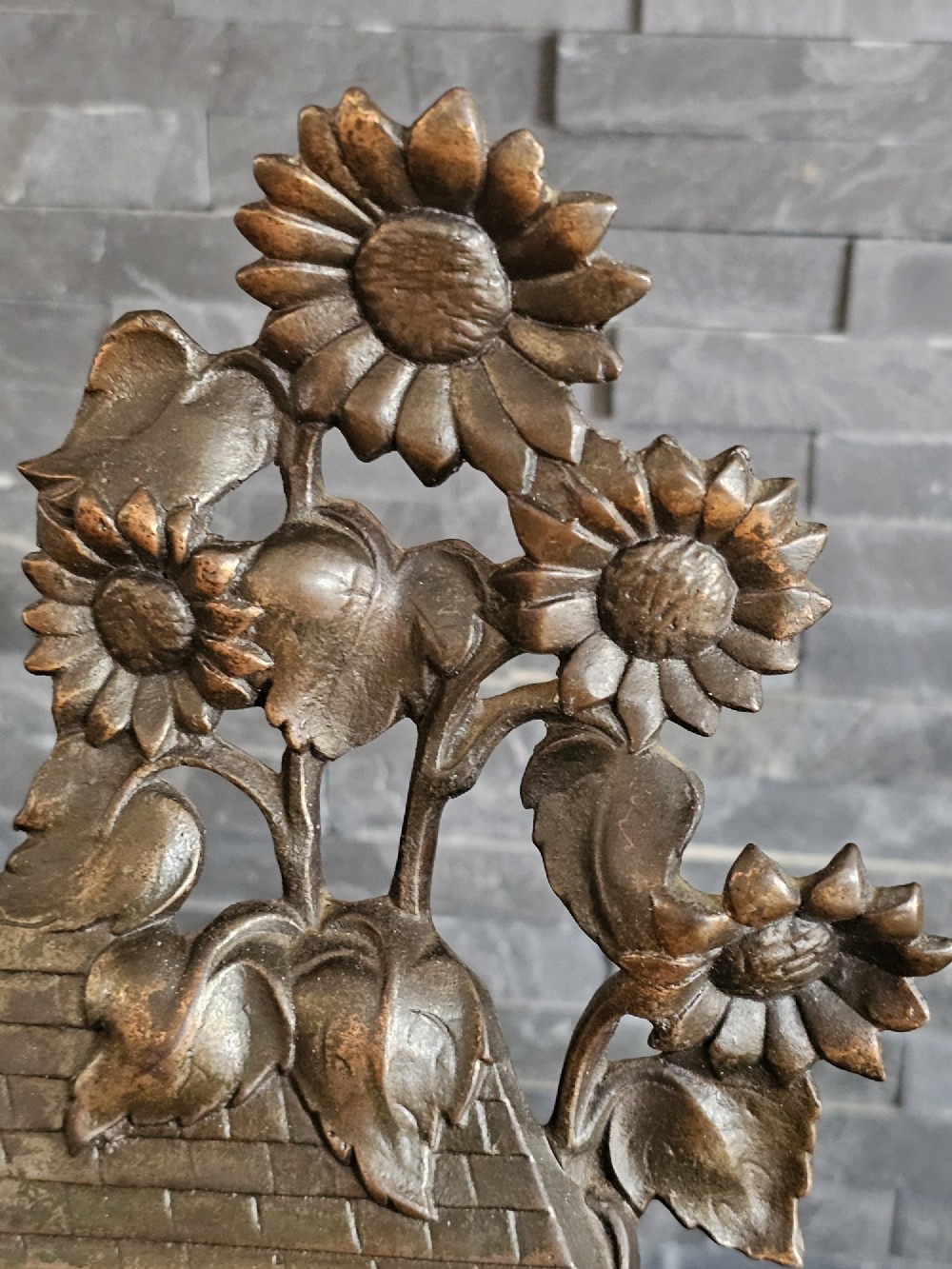 A bronzed Art Deco table clock shaped like a dog kennel with sunflowers on top and a dog figure on the left side of the circular dial. View VII