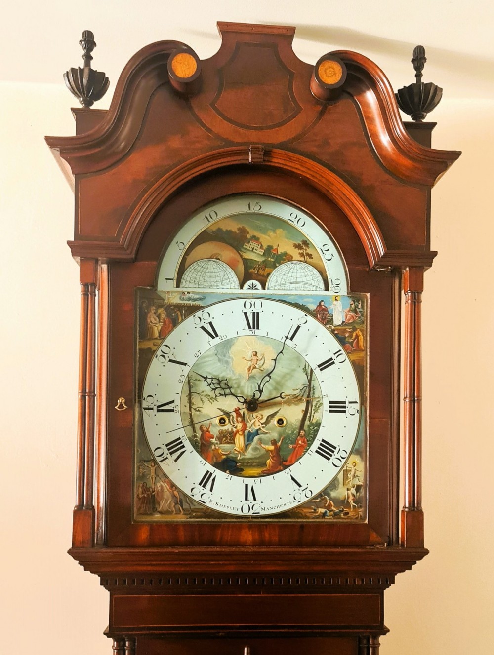 A late 18th-century Georgian mahogany longcase clock featuring a swan-neck pediment, a painted arch dial with moon phase indicator, and a gothic shaped trunk door. View II