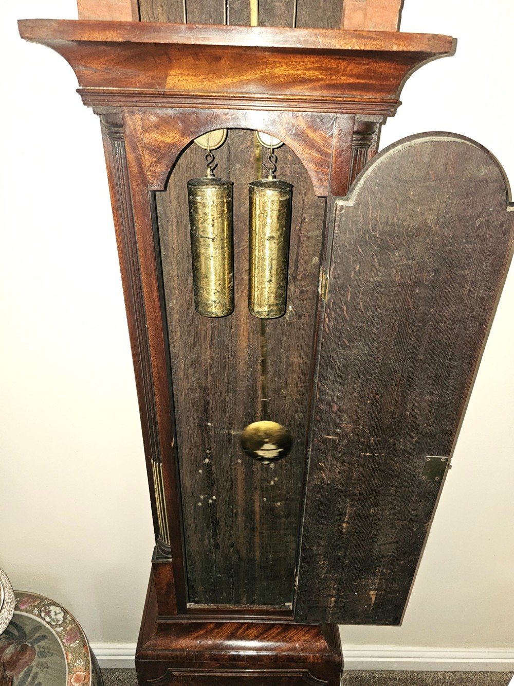 A Georgian flame mahogany longcase clock featuring an arched hood with brass-capped fluted columns, an engraved brass dial with Roman numerals, and a trunk door showcasing rich wood grain. View II