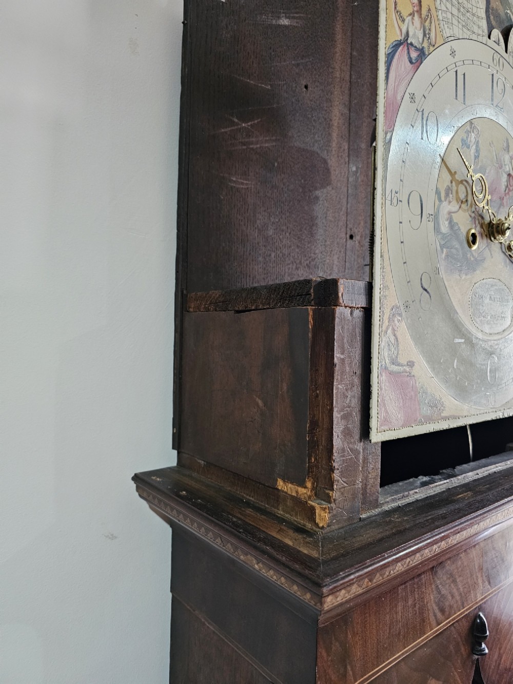 A Regency mahogany longcase clock featuring a swan-neck pediment, a painted dial with a moonphase complication, and a Gothic arch door with flame mahogany veneers. View VIII